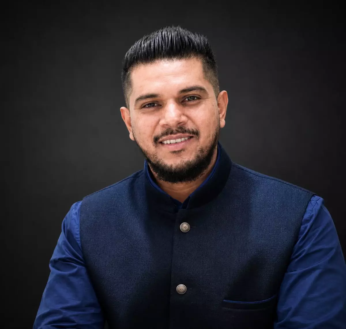 Portrait of Avishek Busviah in a blue shirt and dark waistcoat