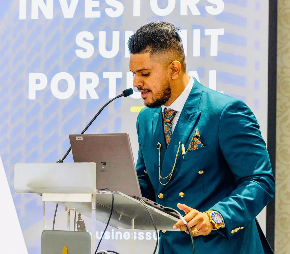Avishek speaking at a podium during the Investors Summit Portugal