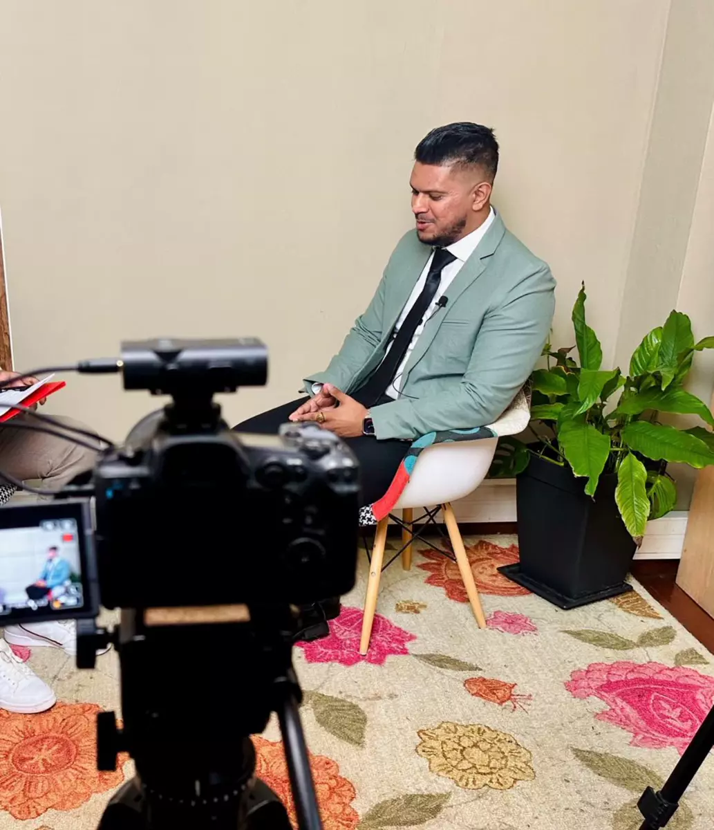 Avishek being interviewed on camera in a studio setting